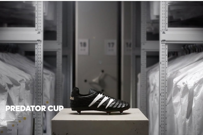 Photo d'une chaussure de football noire Adidas sur un piédestal